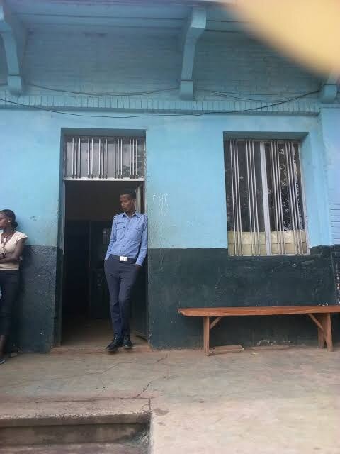 People stand outside a blue-green police station building in Jimma.