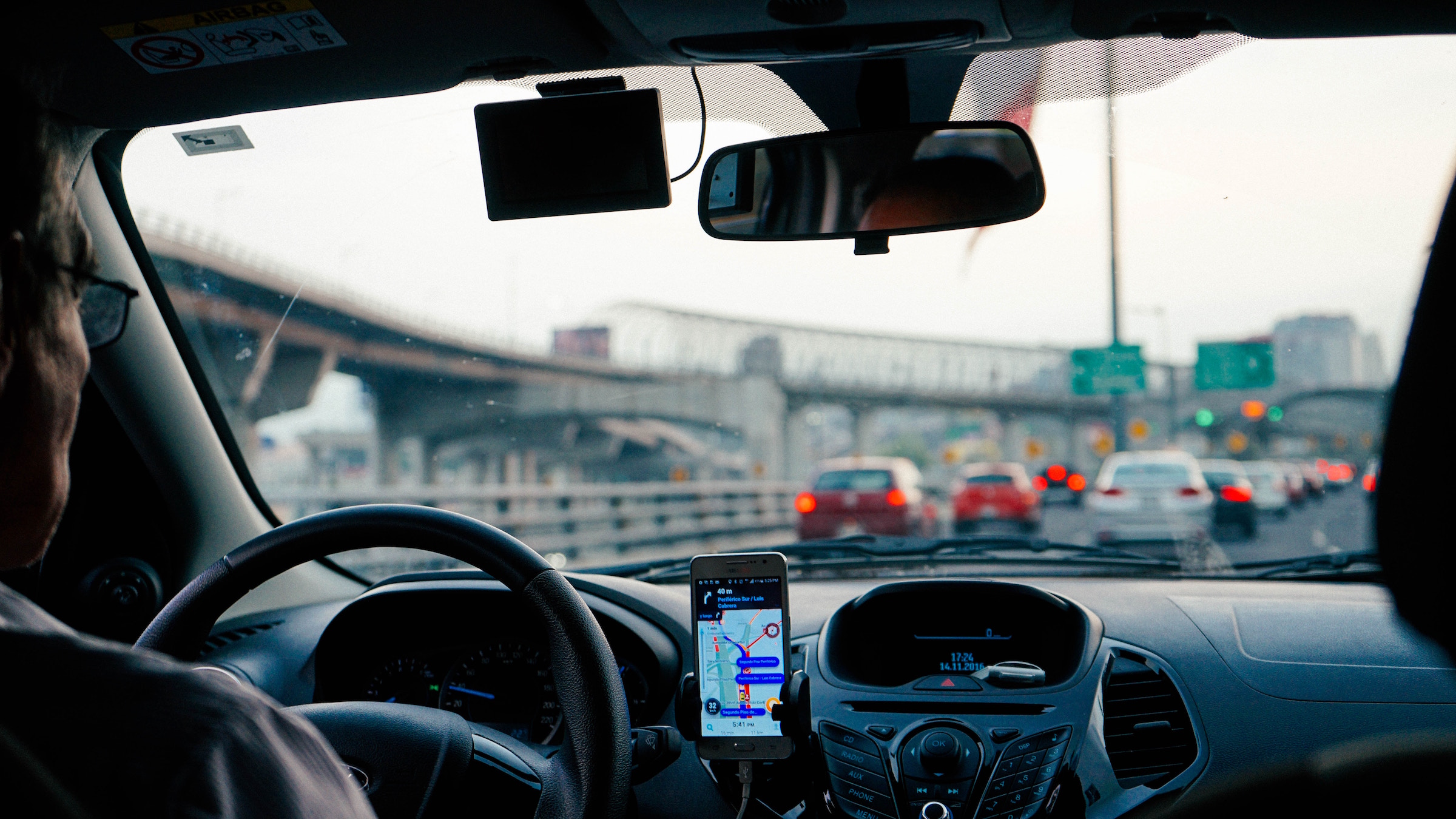 A man sits in his car in traffic.